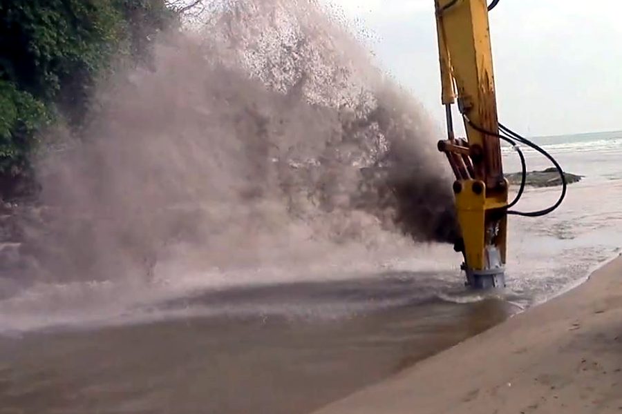 Excavator-mounted Dragflow pump clearing sediment from a waterway